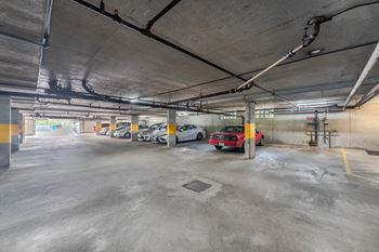A parking garage with a few cars parked inside.